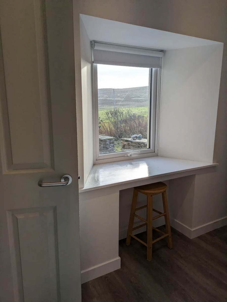 Bedroom window with a wooden stool and views over fields