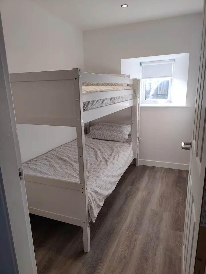 White bunk beds beside the bedroom window