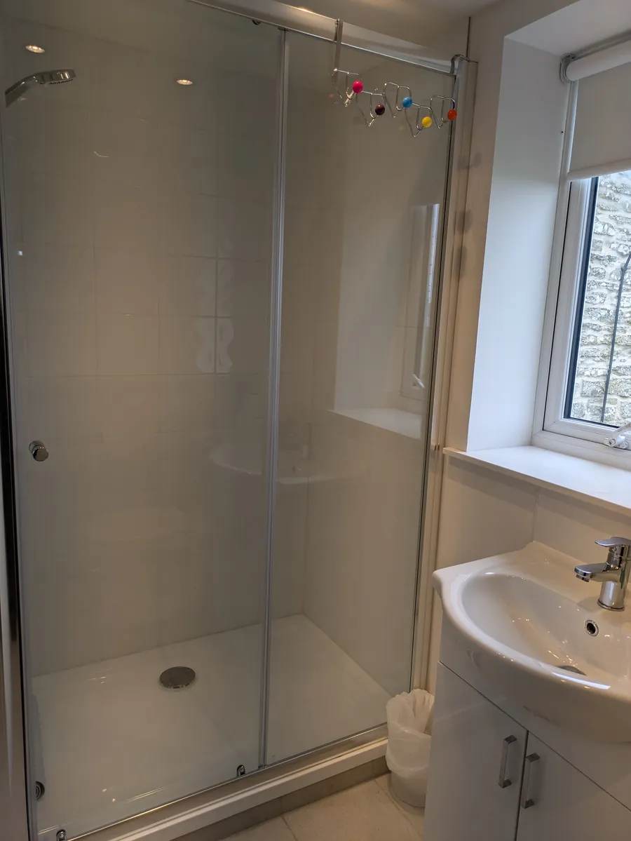 Glass shower enclosure and washbasin in the cottage bathroom