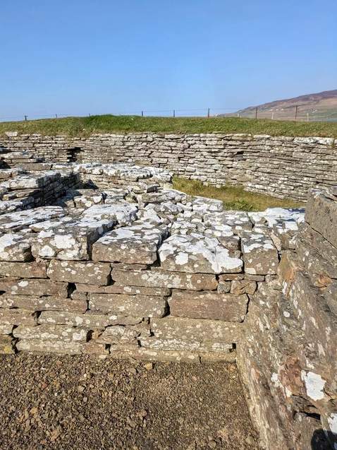 Layers of lichen-covered stonework and a gravel passage at Cubbie Roo’s Castle on Wyre