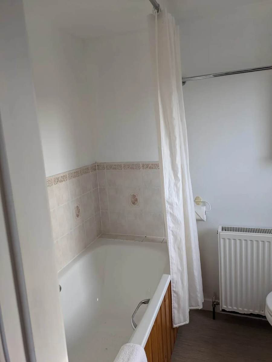 Bath with a shower curtain in the farmhouse bathroom