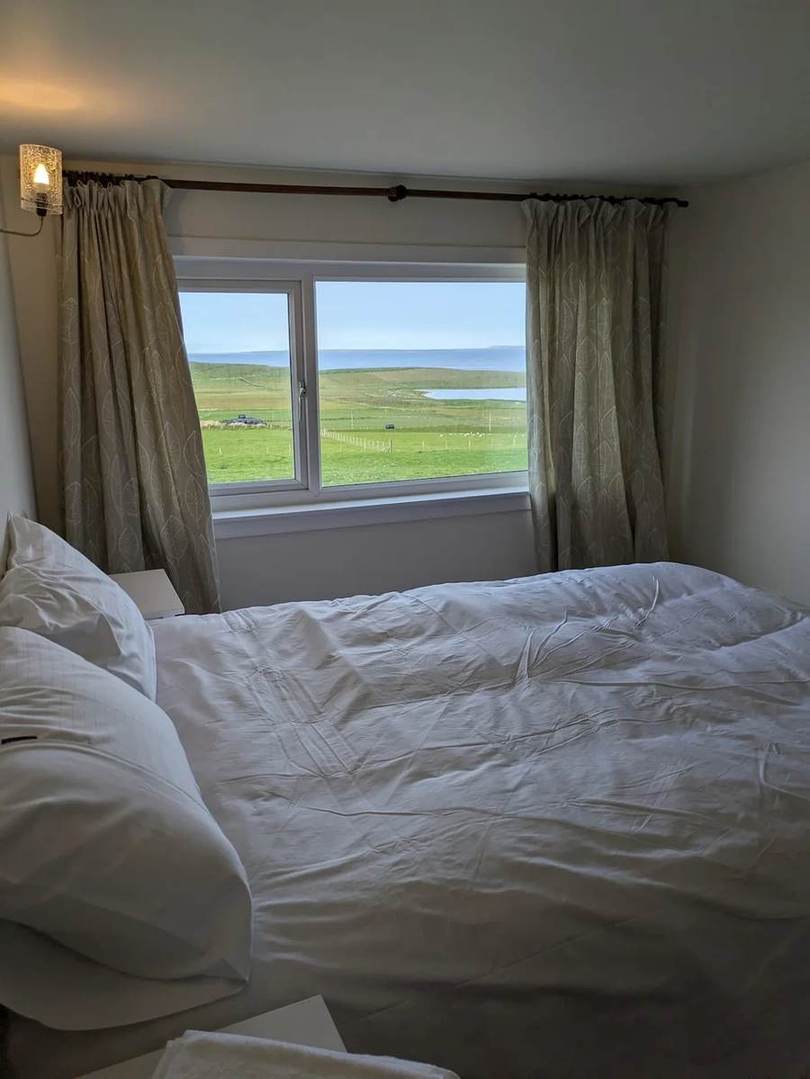 View from the main bedroom across green fields towards the sea