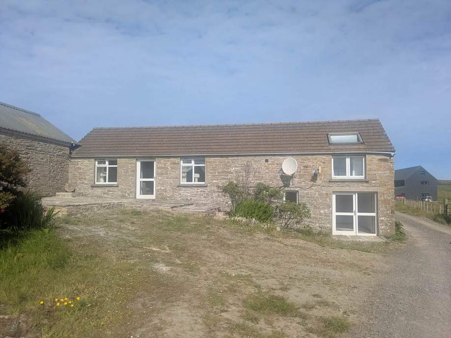 Stone farmhouse with a paved terrace on Rousay