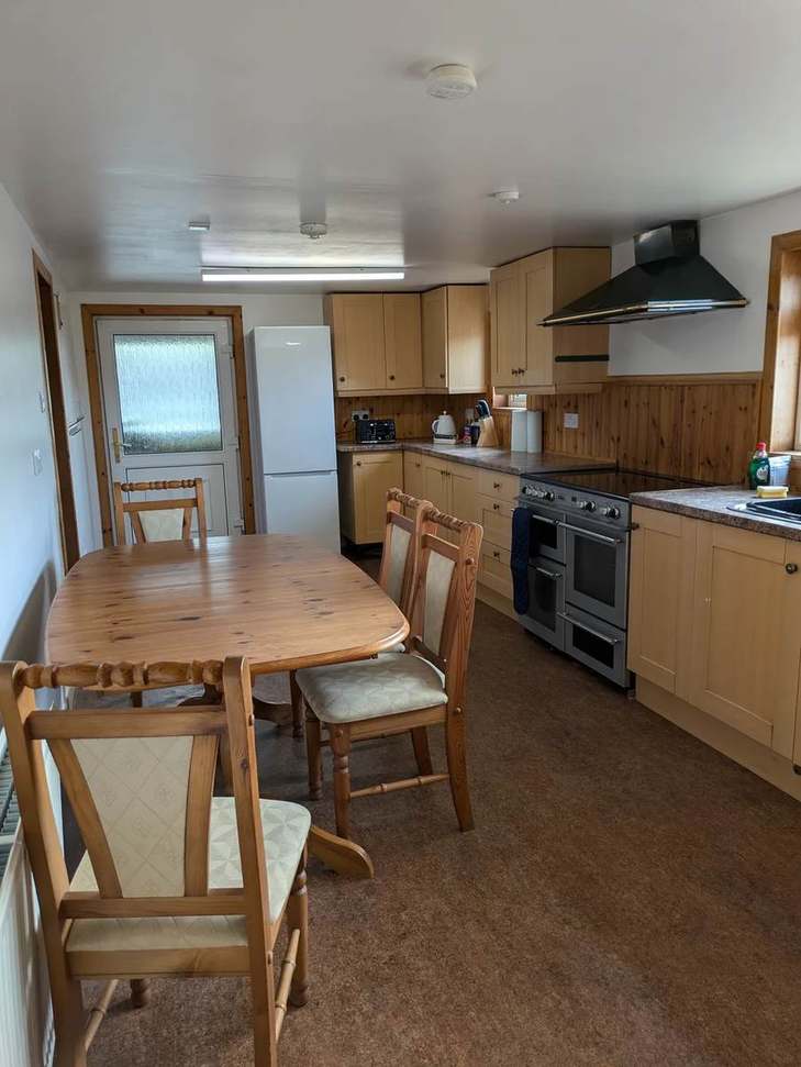 Wooden dining table and range cooker in The Farmhouse kitchen